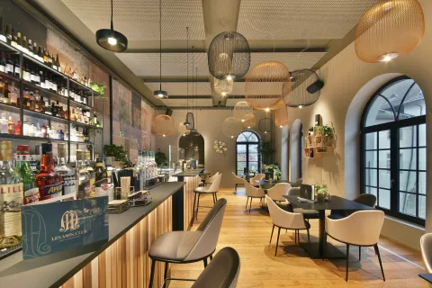 Moderne Bar mit Tischen und Stühlen, Beleuchtung an den Wänden und Deckenleuchten, Steuerung über CASAMBI (Smarthome)