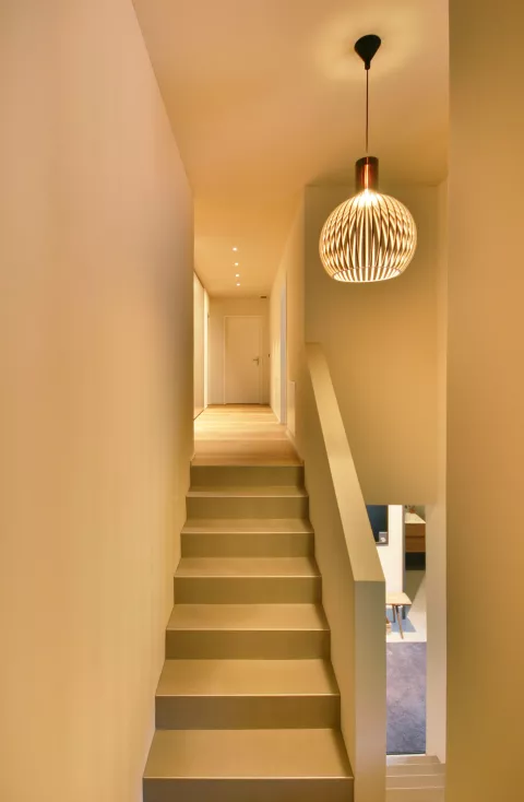 Zwischenpassage zwischen zwei Treppen nach oben, runde hängende von der Decke über der Treppe Lampe, LED-Spots in der Decke im obersten Stockwerk