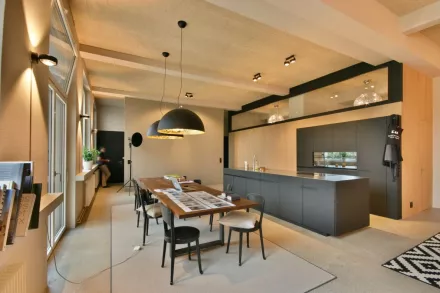 Moderne schwarze Küche und schlichter Holztisch, dunkle Hängeleuchten