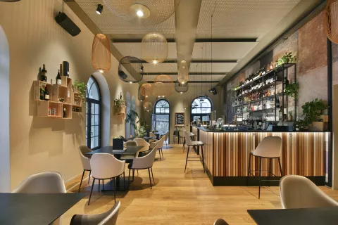 Moderne Bar mit Tischen und Stühlen, Beleuchtung an den Wänden und Deckenleuchten, Steuerung über CASAMBI (Smarthome)